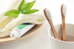 Bamboo toothbrushes and toothpaste aesthetically arranged on a sink countertop